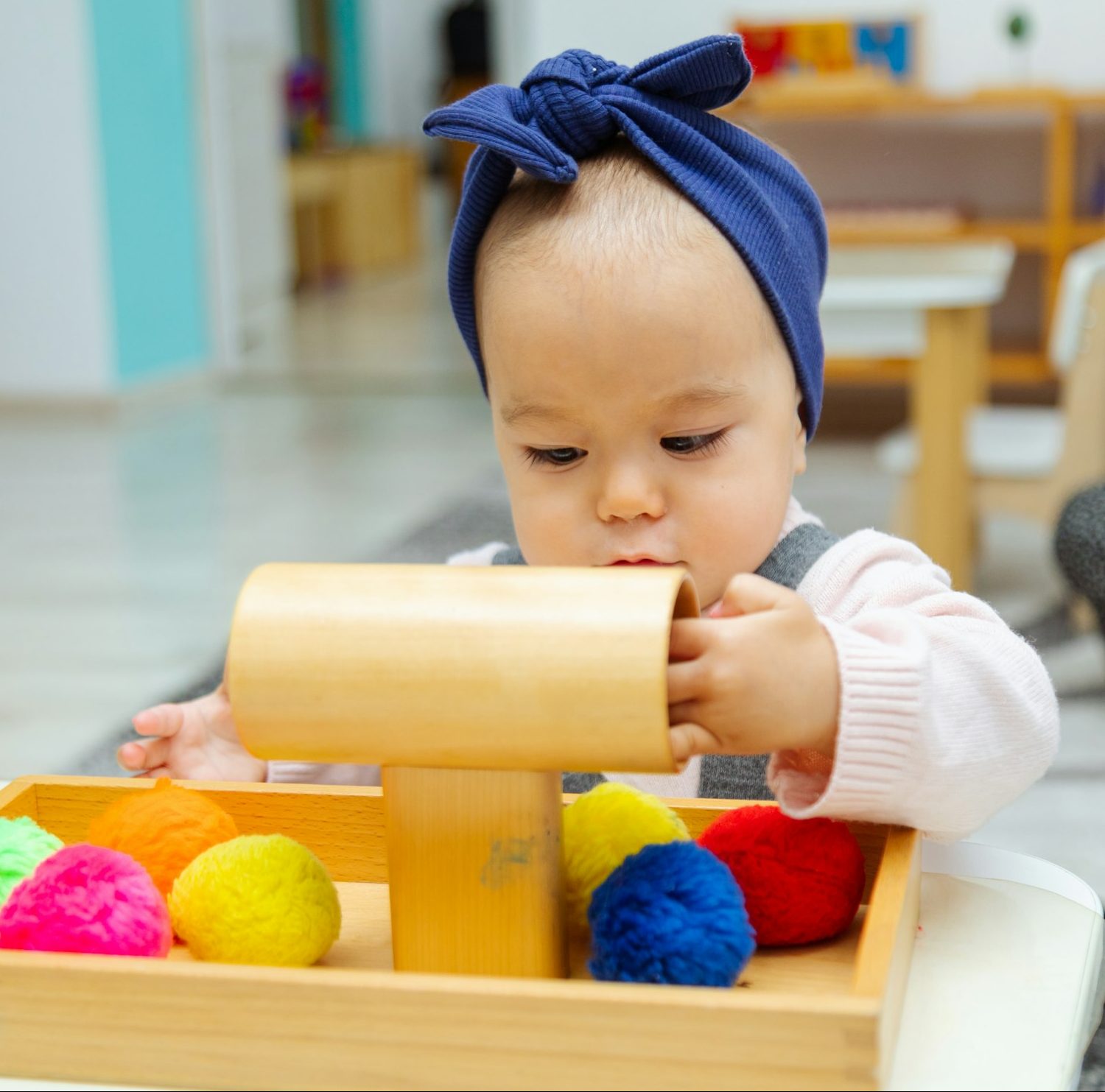 Toddler playing with montessori pompom material